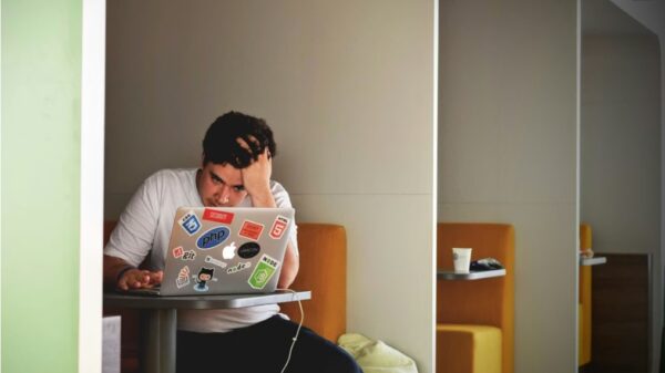 homme portant un haut blanc a laide dun MacBook